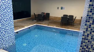 a swimming pool in a room with a table and chairs at Spacious and Cozy 1BR Opal Tower Stunning Marina View in Dubai