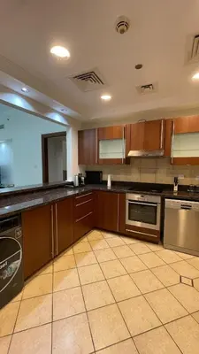a large kitchen with wooden cabinets and stainless steel appliances at Luxury 1-Bedroom, Golden Mile Palm Jumeirah in Dubai