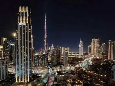 a city skyline at night with a tall building at Ultra-Luxury Apartment | Burj Khalifa Skyline Pool in Dubai