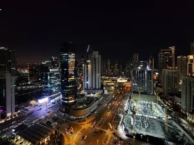 a city lit up at night with buildings and traffic at Ultra-Luxury Apartment | Burj Khalifa Skyline Pool in Dubai