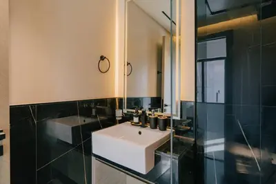 a bathroom with a white sink and a mirror at Luxury 2BR Apt | Infinity Pool with Burj View in Dubai