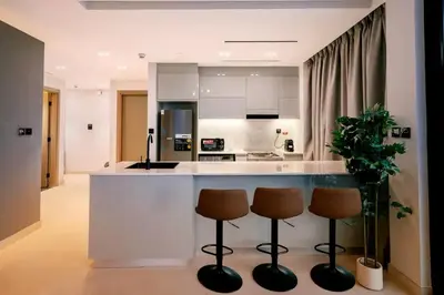 a kitchen with a counter and two stools at Luxury 2BR Apt | Infinity Pool with Burj View in Dubai