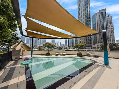 a swimming pool with a large umbrella on top of a building at Ultra-luxury apartment |Stunning Burj Khalifa view in Dubai