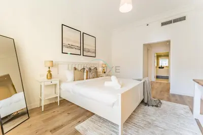 a white bedroom with a large white bed in a room at Exclusive Waterfront Residence with Private Beach Access, Near Palm Jumeirah Mall and Restaurants - Jash Hamad Shoreline B18, Palm Jumeirah by Deluxe Holiday Homes in Dubai