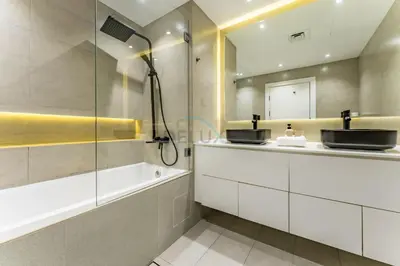 a bathroom with a tub and a sink and a shower at Exclusive Waterfront Residence with Private Beach Access, Near Palm Jumeirah Mall and Restaurants - Jash Hamad Shoreline B18, Palm Jumeirah by Deluxe Holiday Homes in Dubai