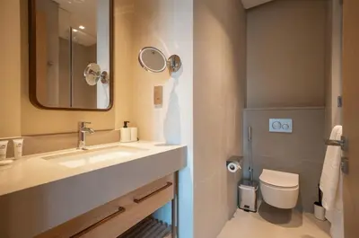 a bathroom with a sink and a toilet and a mirror at 2BR Vida Dubai Mall Burj Khalifa & Fountain View in Dubai