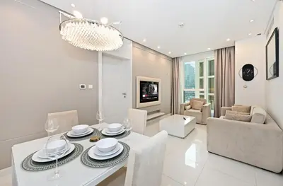 a white dining room with a table and chairs at Bloomfields Luxury 1BR, Damac Voleo, Business Bay in Dubai