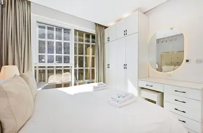 a white bedroom with a white bed and a mirror at Bloomfields Luxury 1BR, Damac Voleo, Business Bay in Dubai