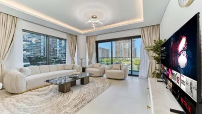 a living room with a large tv and a couch at Contemporary 2BR in Central Park Viridian in Dubai