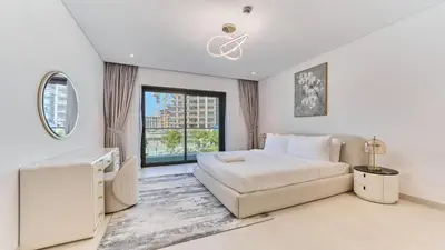 a white bedroom with a bed and a window at Contemporary 2BR in Central Park Viridian in Dubai