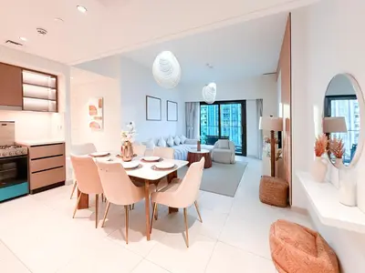 a kitchen and living room with a table and chairs at Burj Crown 3BR Skyline Retreat with Balcony in Dubai