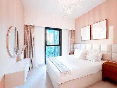 a white bedroom with a large bed and a window at Burj Crown 3BR Skyline Retreat with Balcony in Dubai