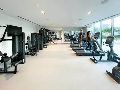 a gym with treadmills and people on tread machines at Burj Crown 3BR Skyline Retreat with Balcony in Dubai