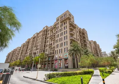 a large building with palm trees in front of it at Silk Valley - Luxury Studio with Pool View - Walk to Park in Dubai