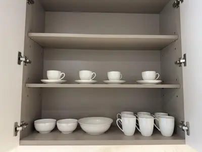 a shelf with white bowls and cups on it at BRAND NEW 2 BDR apartment with beach access in Dubai