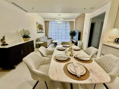 a kitchen and living room with a table and chairs at BRAND NEW 2 BDR apartment with beach access in Dubai