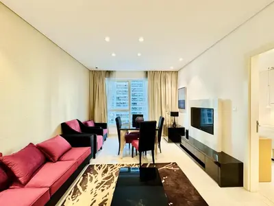 a living room with a red couch and a table at Homes2Retreat - Stylish 1BR with Balcony in Business Bay in Dubai