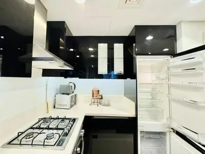 a kitchen with a stove top oven next to a sink at Homes2Retreat - Stylish 1BR with Balcony in Business Bay in Dubai