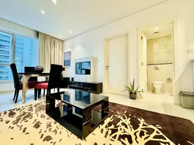 a living room with a table and a dining room at Homes2Retreat - Stylish 1BR with Balcony in Business Bay in Dubai