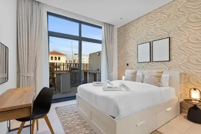 a bedroom with a bed and a desk and a window at Urban Chic 1 Bedroom with big Balcony Kitchen in JVC in Dubai