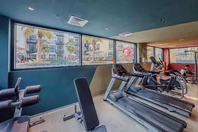 a gym with treadmills and ellipticals in a room at Urban Chic 1 Bedroom with big Balcony Kitchen in JVC in Dubai