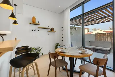 a kitchen and dining room with a table and chairs at Urban Chic 1 Bedroom with big Balcony Kitchen in JVC in Dubai