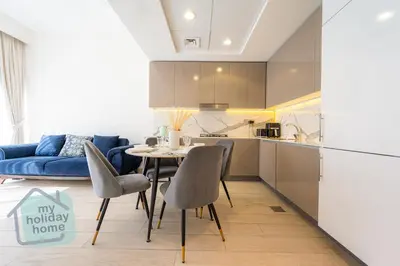 a kitchen and a dining room with a table and chairs at Modern 1BR Azizi Riviera with Pool & Gym in Dubai