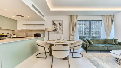a living room with a table and chairs and a couch at Modern 2BR in Viridian Central Park City Walk in Dubai
