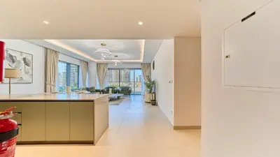 a kitchen and living room with a view of a living room at Modern 2BR in Viridian Central Park City Walk in Dubai