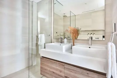 a bathroom with two sinks and a mirror at Frank Porter - Mada Residences in Dubai