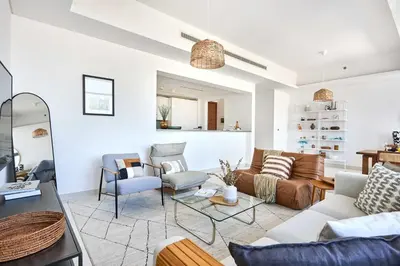 a living room with a couch and chairs at Frank Porter - Mada Residences in Dubai