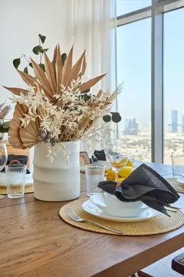 a table with a vase with a plant on it at Frank Porter - Mada Residences in Dubai