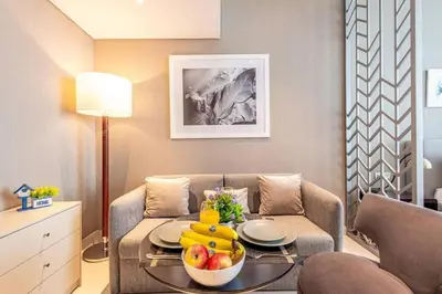 a living room with a table with a bowl of fruit on it at Modern Studio in Business Bay - Canal & City Views - Gym & Pool in Dubai