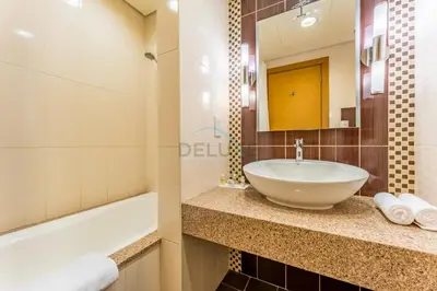 a bathroom with a sink and a bath tub at Spacious 3BR and Assistant Room with Community View - Al Quortaj Villa, Al Furjan by Deluxe Holiday Homes in Dubai