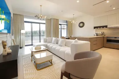 a living room with a white couch and a kitchen at Silk Valley - Luxury Villa | Steps to Park & Pool in Dubai