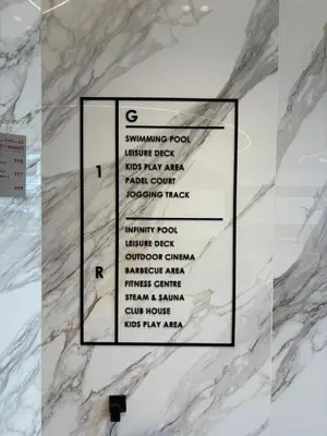 a white marble wall with a sign on it at Deluxe Studio for Rent in Oxford Gardens Dubai in Dubai