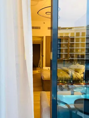 a room with a glass door with two beds in it at Deluxe Studio for Rent in Oxford Gardens Dubai in Dubai