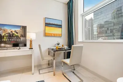 a room with a desk with chairs and a window at DAMAC COUR JARDIN - Near Metro - Free Parking in Dubai