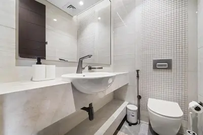 a white bathroom with a sink and a toilet at Modern 2BR at Nobles Tower Near Downtown in Dubai
