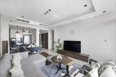 a living room with a couch and a tv at Modern 2BR at Nobles Tower Near Downtown in Dubai