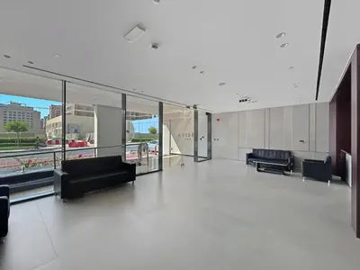a large empty room with couches and chairs in a building at Stylish 1BR Retreat Near World Trade Center Metro in Dubai