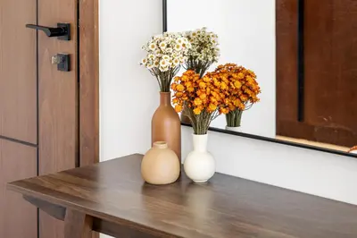 two vases sitting on a table with flowers in them at Stylish 1BR Retreat Near World Trade Center Metro in Dubai
