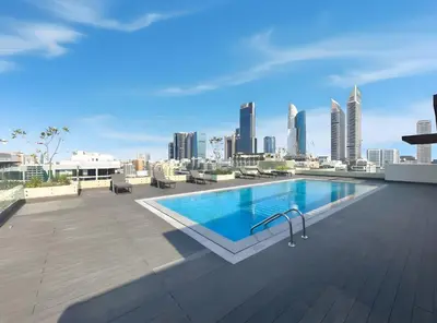 a swimming pool on the roof of a building with a city skyline at Stylish 1BR Retreat Near World Trade Center Metro in Dubai