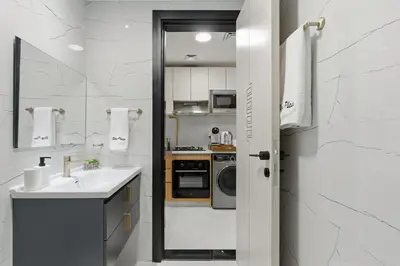 a small kitchen with a sink and a microwave at Modern Studio on 27th Floor with Miracle Garden Views in Dubai