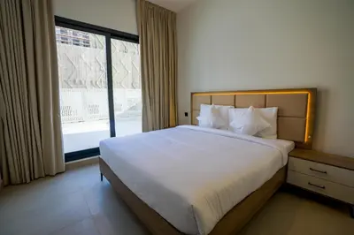 a bedroom with a large bed and a large window at Speedway Vacation Homes Rental LLC in Dubai