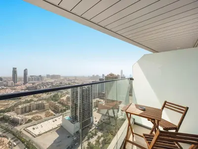 a balcony with a desk and a view of the city at Spacious Studio w Sofa Bed Sleeps 4 in JVC in Dubai