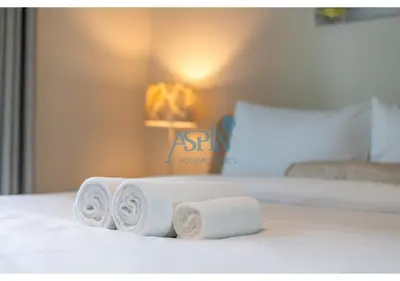 a pile of towels sitting on top of a bed at Aspin Brand New Cozy 1BR at Binghatti Lavender JVC in Dubai