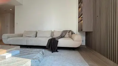 a living room with a couch with a blanket on it at Luxury 2BR in Creek Beach with Lagoon Access in Dubai