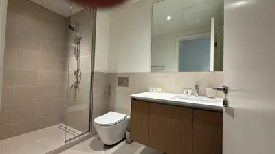 a bathroom with a shower and a toilet and a sink at Luxury 2BR in Creek Beach with Lagoon Access in Dubai