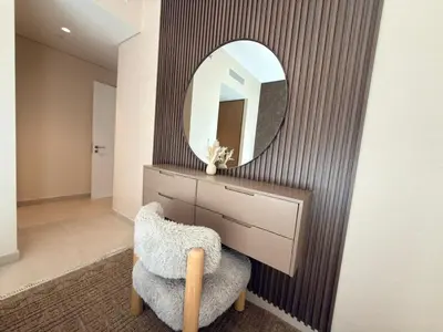 a bathroom with a mirror and a chair and a vanity at Luxury 2BR in Creek Beach with Lagoon Access in Dubai